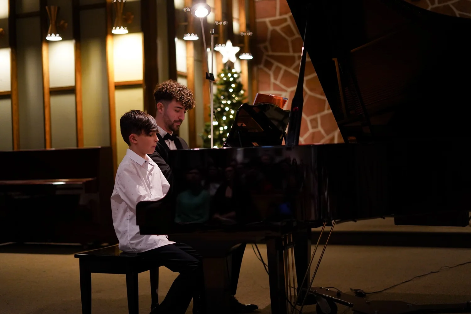 Jean-Baptiste accompagne un jeune élève lors d’un concert PianoPiano!
