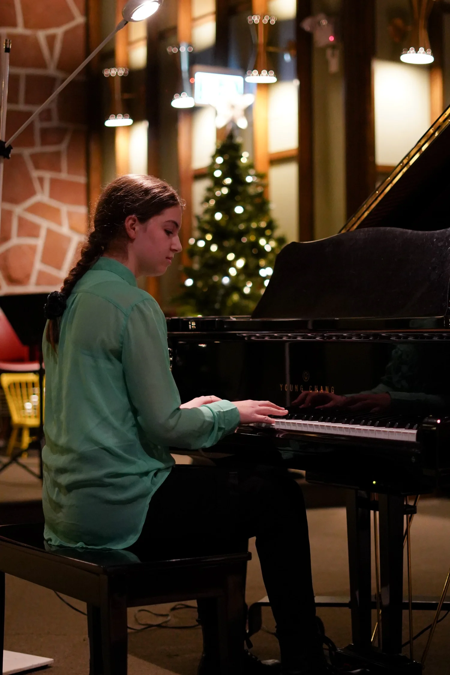 Une élève joue du piano sur scène